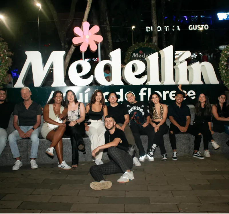 Native paisa guide leading a small group of travellers through Provenza rooftop bars on a Medellin nightlife like a local tour at dusk