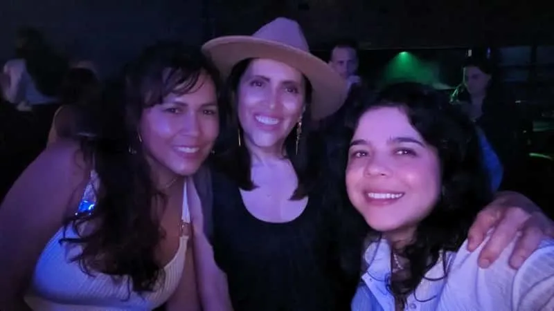 Small group of travellers dancing at a Provenza rooftop bar with a local paisa guide on a Medellin nightlife like a local tour at night